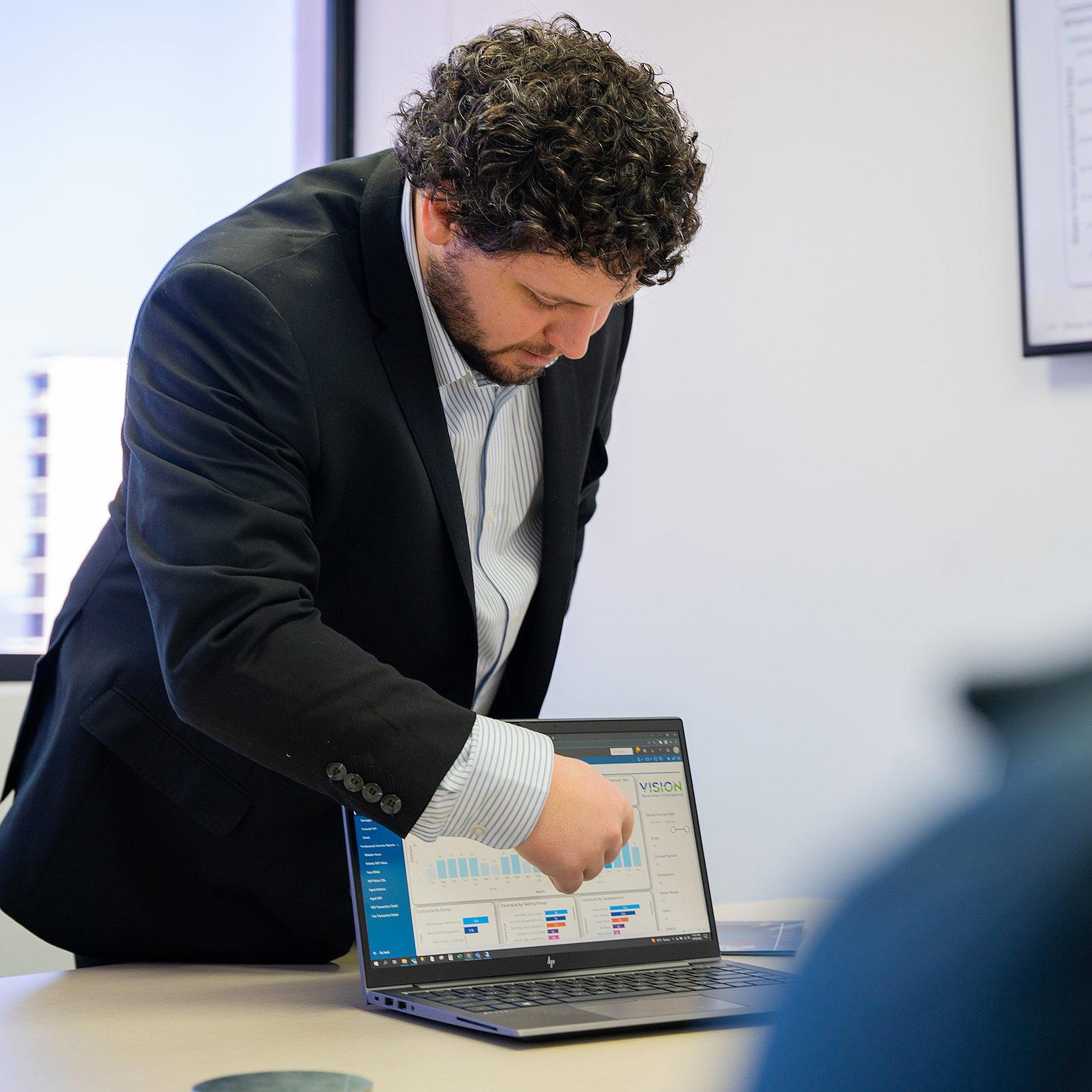 a man pointing to a laptop screen showing data sets